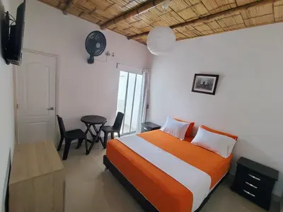a bedroom with a bed and a table and chairs at Hotel campestre París soleil in Mariquita