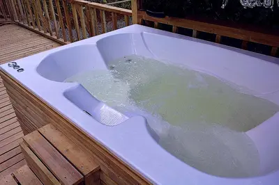 a bath tub filled with water on a deck at Cabaña Madre Selva in San Vicente