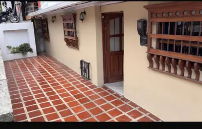 a brick walkway next to a building with a door at El Corazón de chila a 3 cuadras del parque principal in Carmen de Viboral