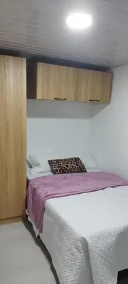 a bedroom with a bed with a purple blanket at El Corazón de chila a 3 cuadras del parque principal in Carmen de Viboral