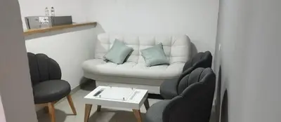a living room with a white couch and two chairs at El Corazón de chila a 3 cuadras del parque principal in Carmen de Viboral