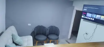 a meeting room with two chairs and a screen at El Corazón de chila a 3 cuadras del parque principal in Carmen de Viboral
