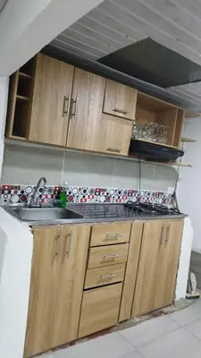 a kitchen with a sink and wooden cabinets at El Corazón de chila a 3 cuadras del parque principal in Carmen de Viboral