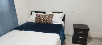 a bedroom with a bed and a night stand at El Corazón de chila a 3 cuadras del parque principal in Carmen de Viboral