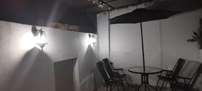 a room with a table and chairs and an umbrella at El Corazón de chila a 3 cuadras del parque principal in Carmen de Viboral