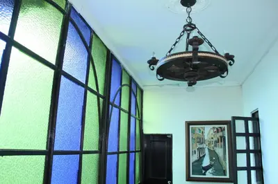 a room with a chandelier and stained glass windows at Hotel Colonial - Salamina Caldas in Salamina