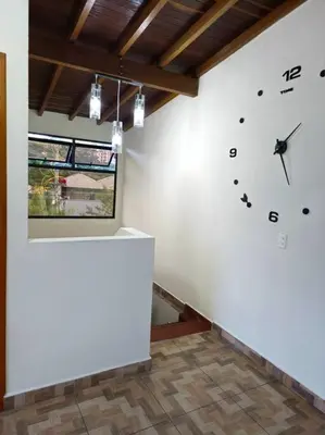 a room with a white wall with a clock on the wall at Espacioso y lindo lugar in Bello