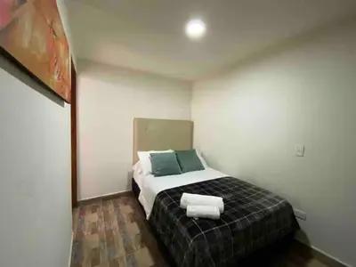 a bedroom with a bed with two towels on it at Apartamento en Envigado al Sur de Medellin in Envigado