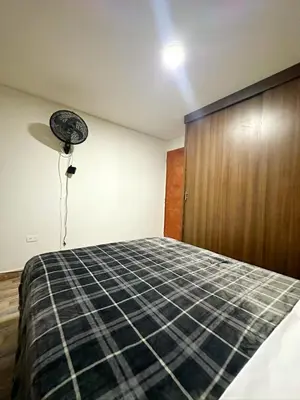 a bedroom with a bed and a wooden door at Apartamento en Envigado al Sur de Medellin in Envigado