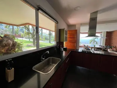 a kitchen with a sink and a large window at Poblado Villa Great views Nature Jacuzzi Security in Medellín
