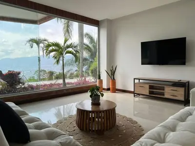 a living room with a couch and a tv at Poblado Villa Great views Nature Jacuzzi Security in Medellín