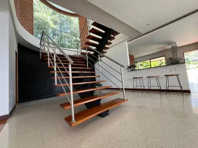 a spiral staircase in a house with a table and stools at Poblado Villa Great views Nature Jacuzzi Security in Medellín