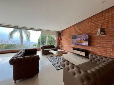 a living room with leather furniture and a brick wall at Poblado Villa Great views Nature Jacuzzi Security in Medellín