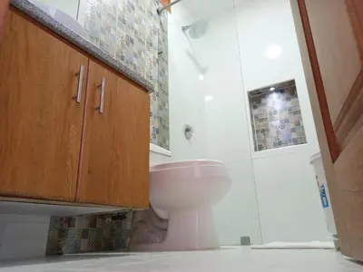 a bathroom with a pink toilet and a shower at Casa Finca Hotel Loma Encantada in Guatapé