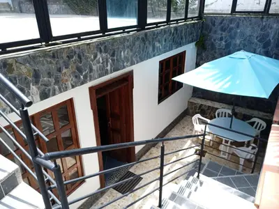 a view from the stairs of a building with a blue umbrella at Casa Finca Hotel Loma Encantada in Guatapé
