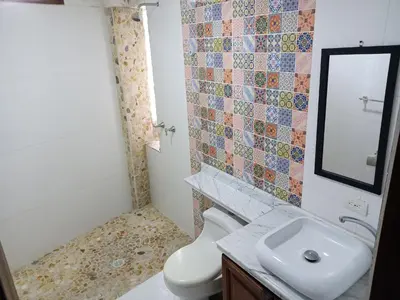 a bathroom with a toilet and a sink and a mirror at Casa Finca Hotel Loma Encantada in Guatapé