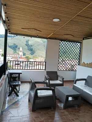 a room with chairs and a table and windows at edificiourrao in Urrao