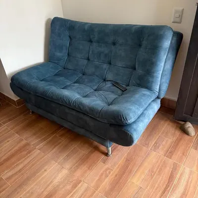 a blue couch in a room with a wooden floor at edificiourrao in Urrao