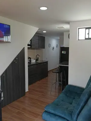 a living room with a couch and a kitchen at edificiourrao in Urrao