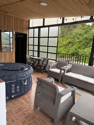 a large room with a hot tub and chairs at edificiourrao in Urrao