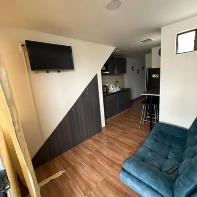 a living room with a couch and a television on a wall at edificiourrao in Urrao