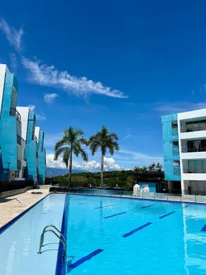 a large swimming pool with palm trees in the background at Apartamento Vacacional San Jerónimo in Medellín