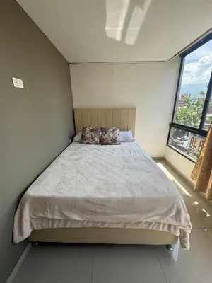 a bedroom with a bed with two pillows on it at Amplio apartamento en la 70 Estadio Laureles para grupos familiares o amigos in Medellín