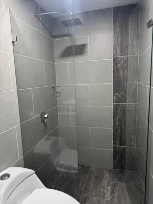 a bathroom with a toilet and a glass shower at Amplio apartamento en la 70 Estadio Laureles para grupos familiares o amigos in Medellín