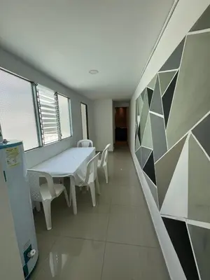 a white room with a table and chairs in it at Amplio apartamento en la 70 Estadio Laureles para grupos familiares o amigos in Medellín