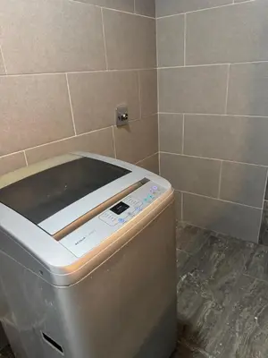 a washing machine in a bathroom with a tile wall at Amplio apartamento en la 70 Estadio Laureles para grupos familiares o amigos in Medellín