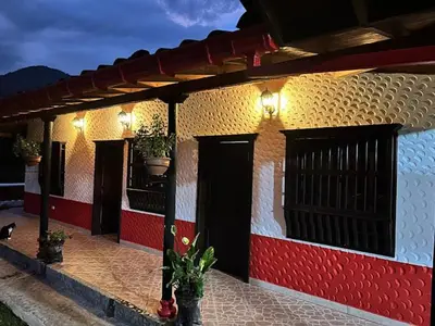 a house with a red and white wall with plants on it at Hostal Artesanos in Jardin
