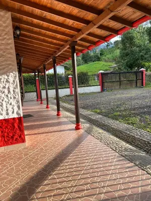 a pavilion with red poles on a brick sidewalk at Hostal Artesanos in Jardin