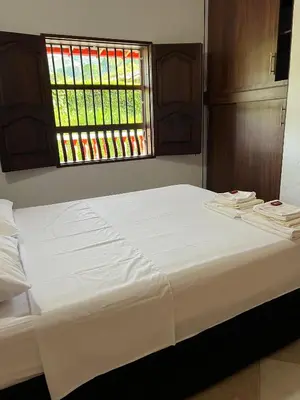 a white bed in a room with a window at Hostal Artesanos in Jardin