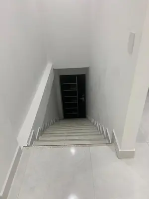 a staircase with a black door in a white room at Habitaciones en Doradal 203 in Doradal