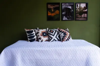a green bedroom with a bed with pillows on it at RíoBosque Cabañas de lujo frente al rio desayuno incluido san carlos antioquia in San Carlos