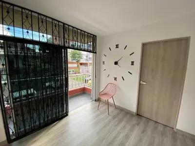 a room with a clock on the wall and a chair at Espectacular vista panorámica de norte a sur in Bello