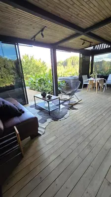 a living room with a couch and a table on a deck at Villa Deluxe Curazao in El Peñol