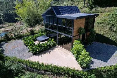 a small house with a solar roof in a garden at Villa Deluxe Curazao in El Peñol