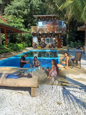 a group of people sitting next to a swimming pool at Finca LA CASCADA in Mesa del Norte