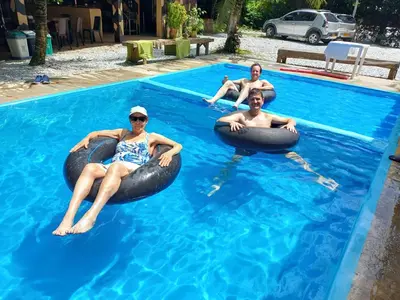 three people in the swimming pool on bean bags in the water at Finca LA CASCADA in Mesa del Norte