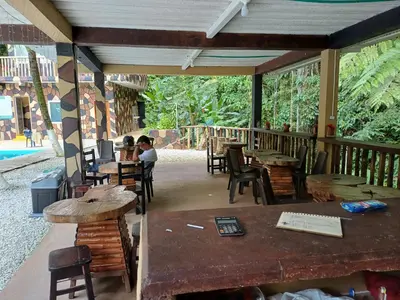 a patio with tables and people sitting at tables at Finca LA CASCADA in Mesa del Norte