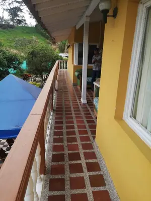 a porch of a house with a brick walkway at Finca Villa Cristian Copacabana Antioquia in Copacabana