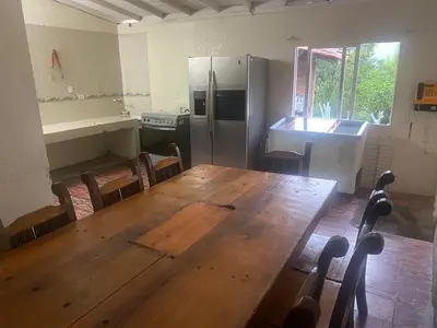 a kitchen with a wooden table and a refrigerator at Finca Villa Cristian Copacabana Antioquia in Copacabana