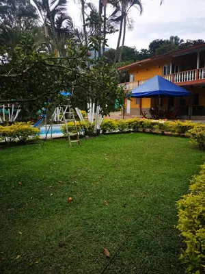 a playground in a yard next to a building at Finca Villa Cristian Copacabana Antioquia in Copacabana
