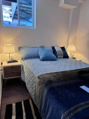a bedroom with a bed and a nightstand with two lamps at Casa Boutique La Corona Medellin in Envigado