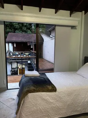 a bedroom with a large window with a view of a deck at Casa Boutique La Corona Medellin in Envigado
