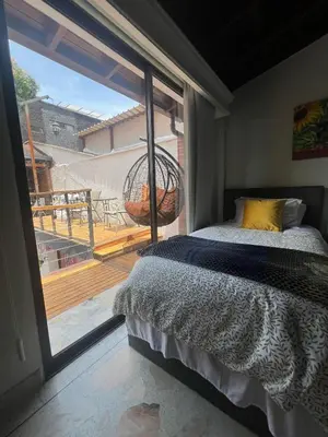 a bedroom with a bed and a view of a balcony at Casa Boutique La Corona Medellin in Envigado