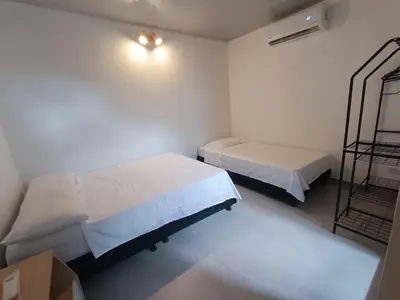 a small room with two beds and a shelf at CASA JAZZ Armonía y relax in Mariquita