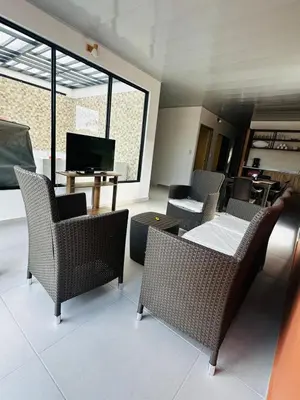a living room with chairs and a table and a television at CASA JAZZ Armonía y relax in Mariquita