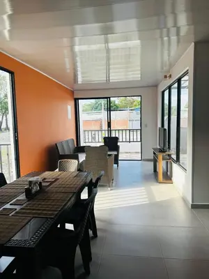 a living room with a table and chairs and a television at CASA JAZZ Armonía y relax in Mariquita
